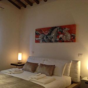 Simple room with a double bed and soft lighting.