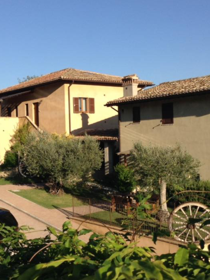 A building located in a rural area, surrounded by fields and trees.