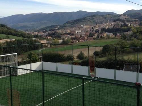 A sports field located on a hill, surrounded by lush green landscape and nature.
