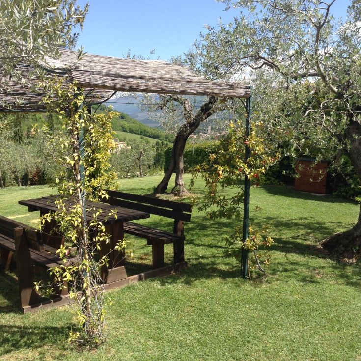 A peaceful corner in the countryside, featuring a wooden table and a view of the hills.
