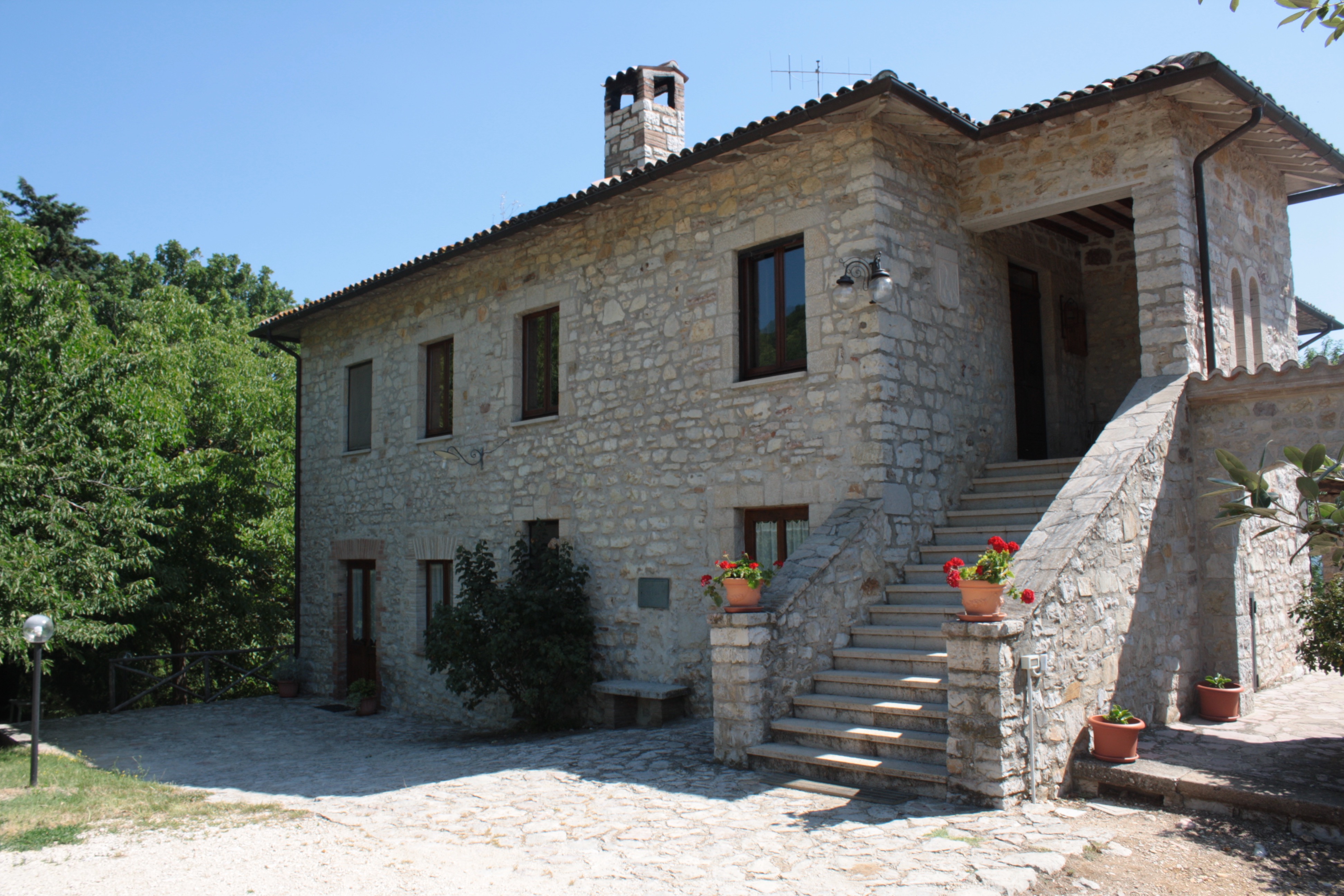 Un agriturismo circondato da spazi verdi in Umbria, perfetto per momenti di tranquillità e passeggiate all'aperto.