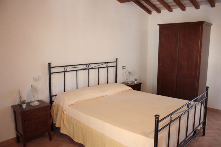 Simple space with a double bed and understated wooden furniture.