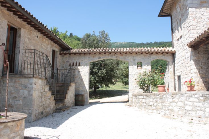 A stone building surrounded by the nature of the Umbrian countryside.