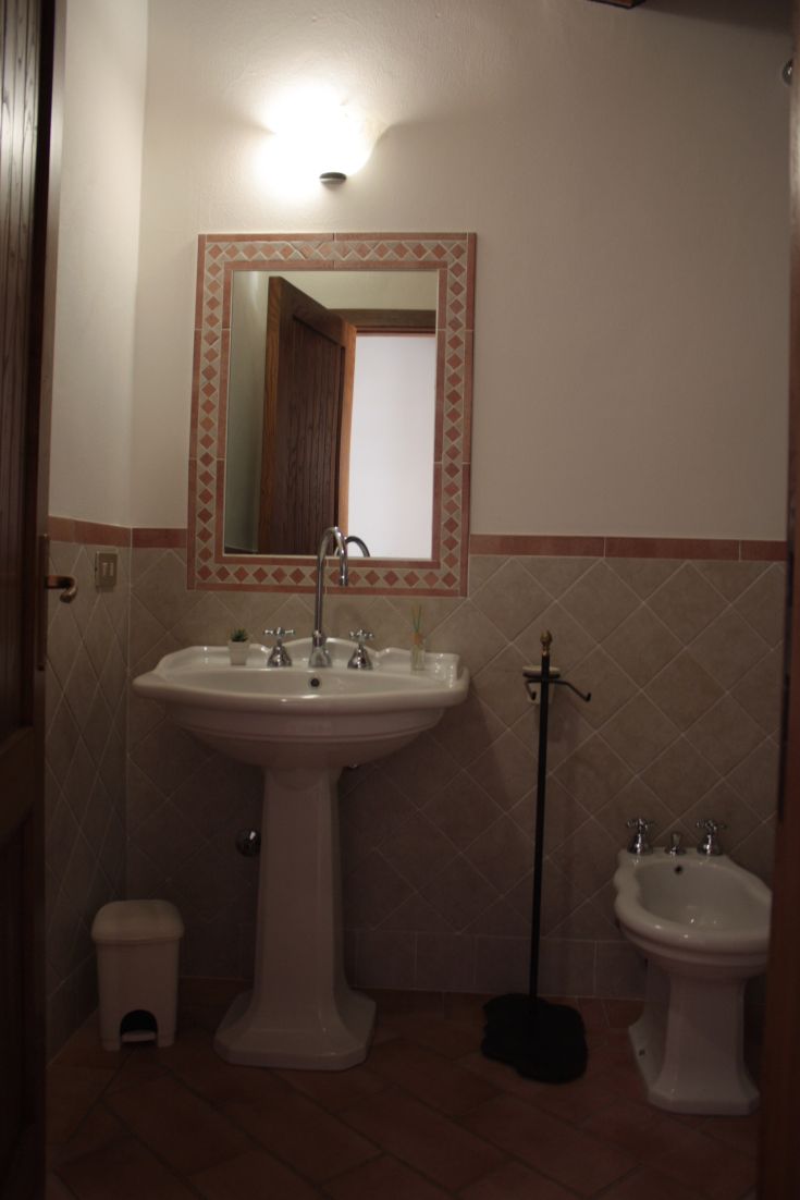 Interior of a modern bathroom with sink and bidet, featuring ceramic materials and understated finishes.