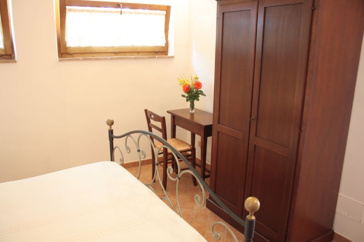 A simple room with wooden furniture and some fresh plants.