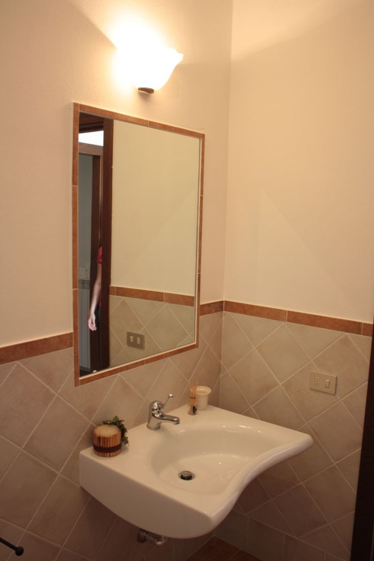 A contemporary bathroom featuring a designer sink and mirror, illuminated by soft lighting.