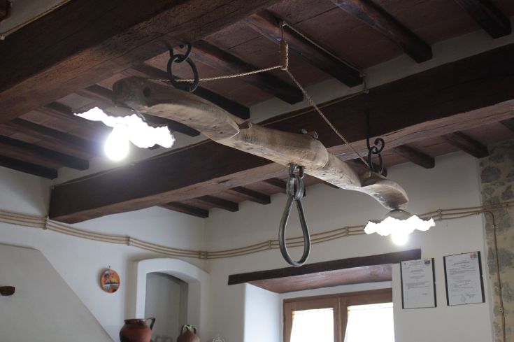 Interior of a farmhouse with wooden beams and hanging lamps, creating a relaxing atmosphere.