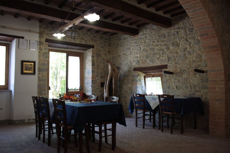 Interiors of a farmhouse with wooden tables and rustic details.