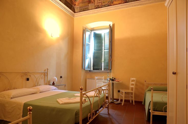 Gemütlicher Raum mit Eisenbetten und gutem Tageslicht, ideal für einen ruhigen Aufenthalt.