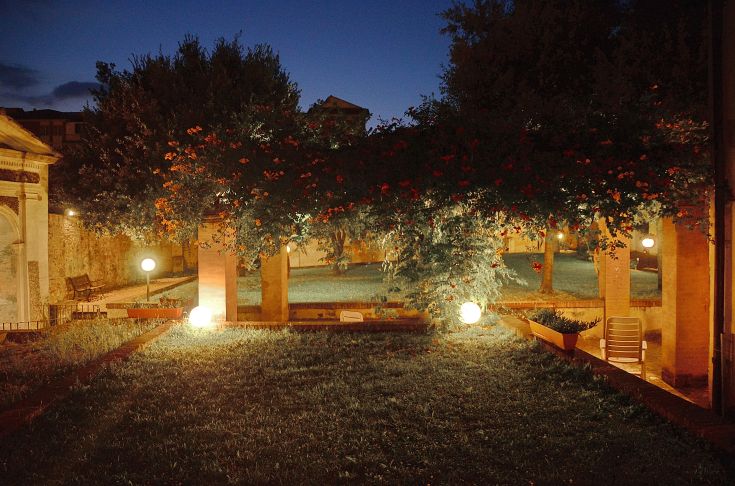 Ein Innenhofgarten in einem Gebäude mit Pflanzen und Beleuchtung, die zur Schaffung einer ruhigen Umgebung beitragen.