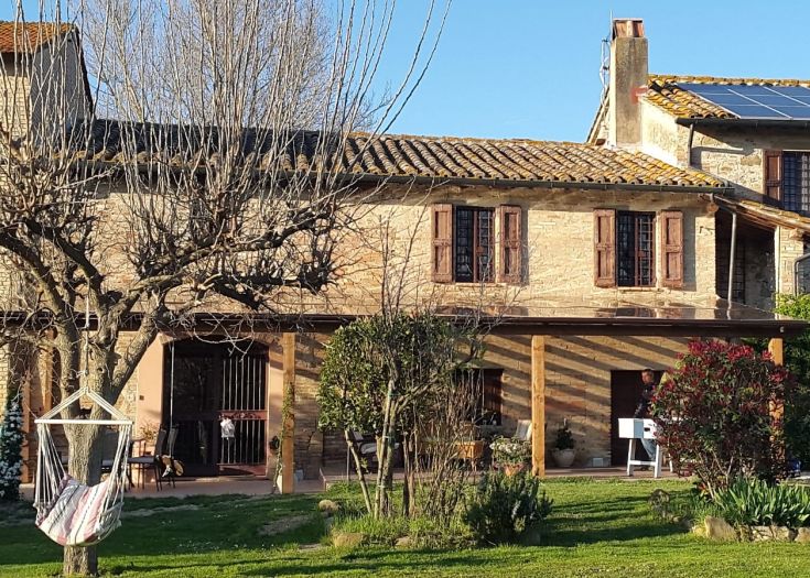 Une maison à la campagne avec un jardin bien entretenu, idéale pour profiter de moments de détente.