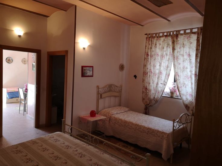 Une chambre simple avec des lits jumeaux et des fenêtres décorées de fleurs.