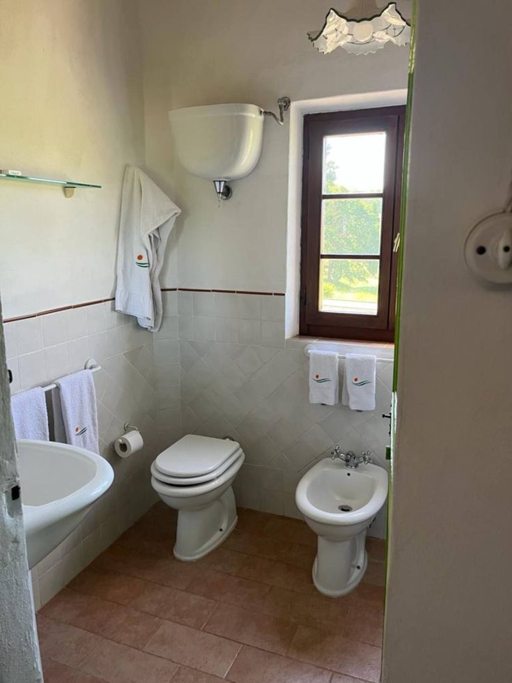 Ein geräumiges und gut beleuchtetes Badezimmer mit einem Fenster, das natürliches Licht hereinlässt.
