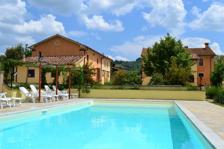 Una fattoria con piscina situata tra le colline, ideale per una pausa rilassante e per esplorare il paesaggio naturale.