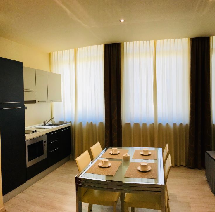 Intérieur d'un bâtiment moderne et confortable, avec une cuisine équipée et un salon lumineux.