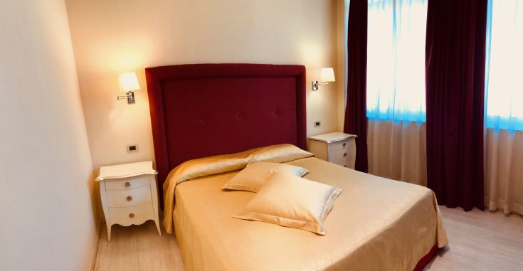 Chambre confortable avec des lits douillets et des rideaux colorés, parfaite pour un séjour relaxant.