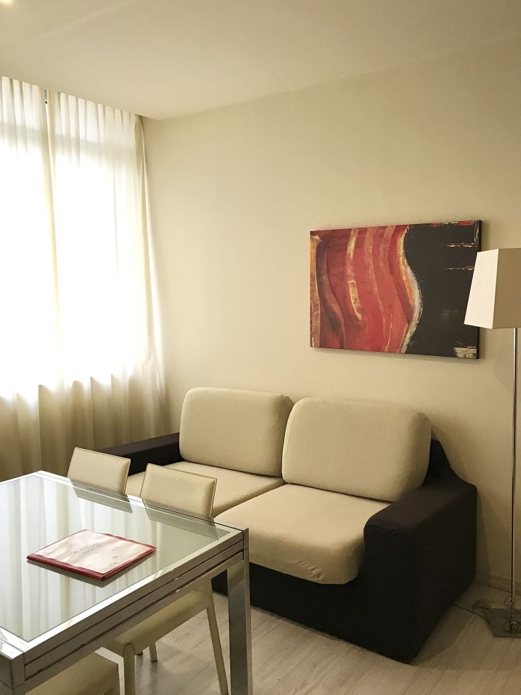 Salon moderne et lumineux, aménagé avec un canapé et une table, parfait pour des moments de détente.