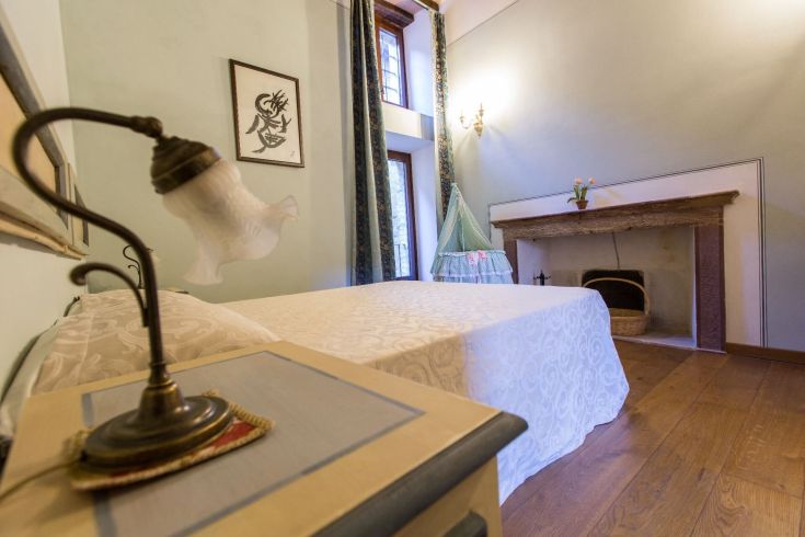 Camera confortevole con letto matrimoniale e camino, perfetta per un soggiorno tranquillo.