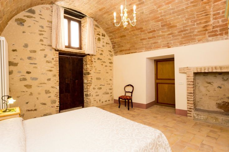 Ambiente spazioso con soffitti alti e decorazioni sobrie in un edificio storico.