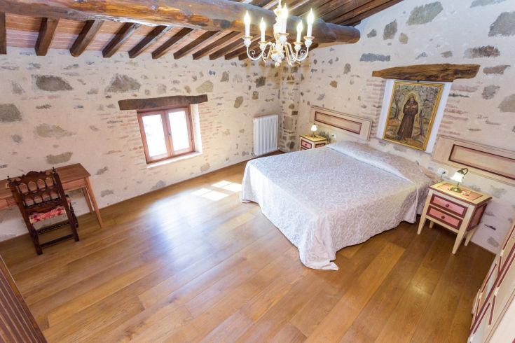 Camera sobria con dettagli storici, adatta per momenti di relax e tranquillità.