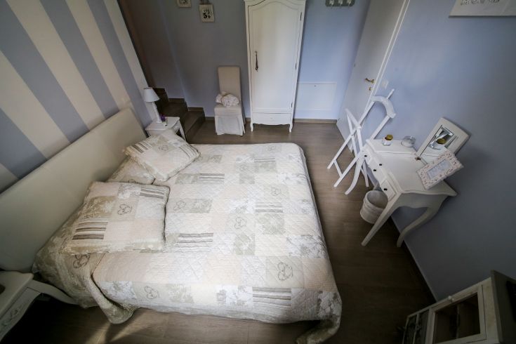 A simple bedroom with shabby chic decorations, perfect for a cozy rest.