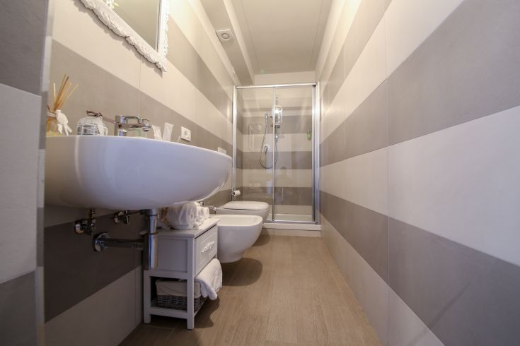 Modern bathroom with wooden floors and striped walls. Bright and comfortable atmosphere.