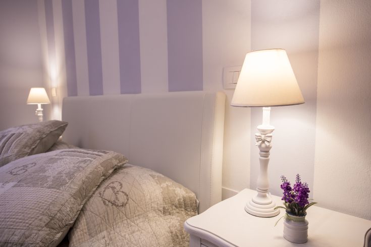 Cozy room with a bed and a lamp, perfect for a peaceful stay.