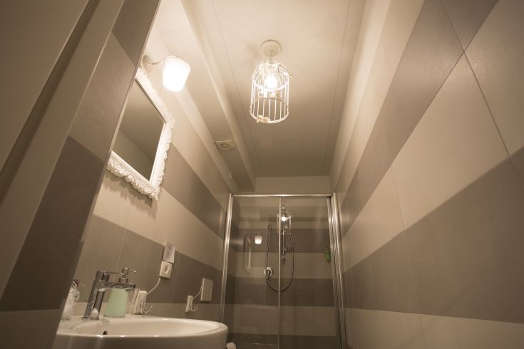 Elegant bathroom with striped tiles and a classic chandelier.
