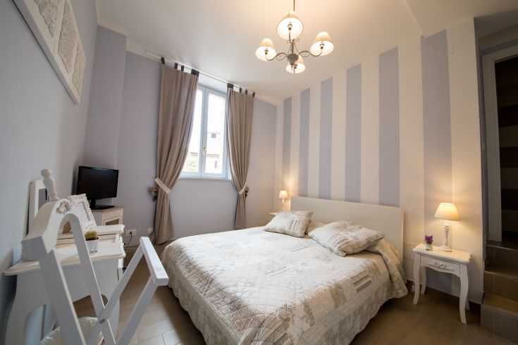 A simple and tidy bedroom furnished in shabby chic style, perfect for a peaceful stay.