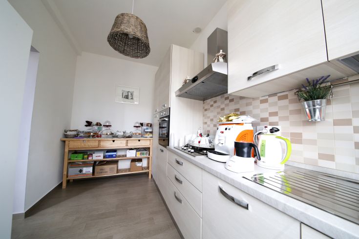 Modern and cozy kitchen featuring shabby chic details, overlooking a quiet square.