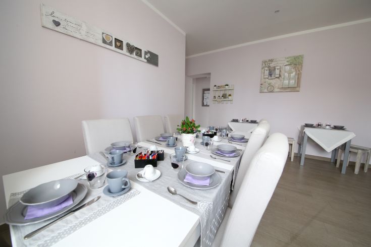 A table set for a meal, adorned in gray with accents of violet.