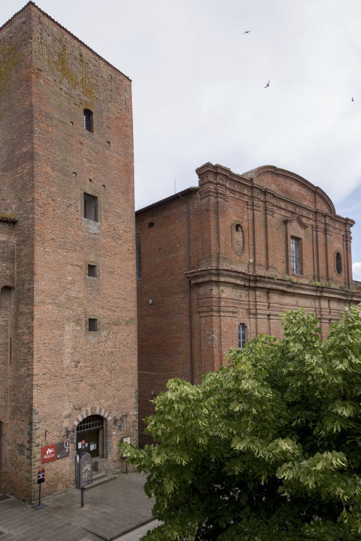 Panorama of the historic structure featuring a tower and adjacent building in a modest medieval style.