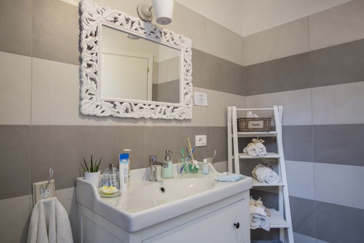 Simple bathroom with a mirror and informal style furniture.