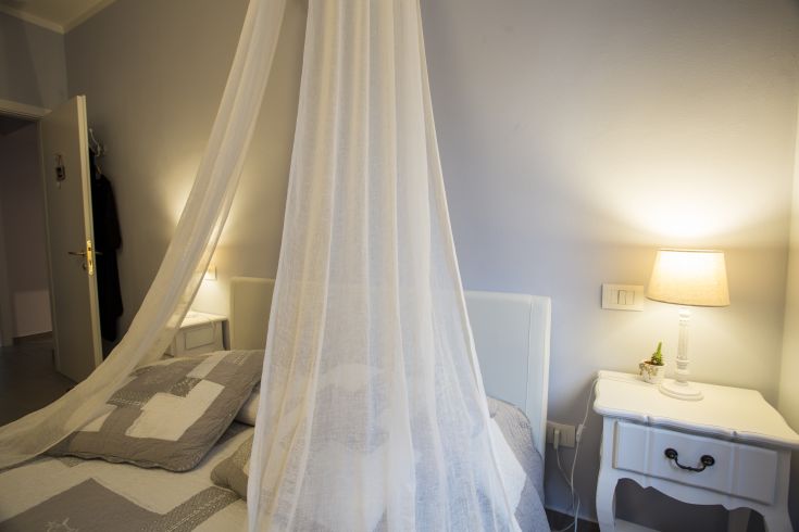 A simple room with a four-poster bed and soft lighting, perfect for a relaxing stay.