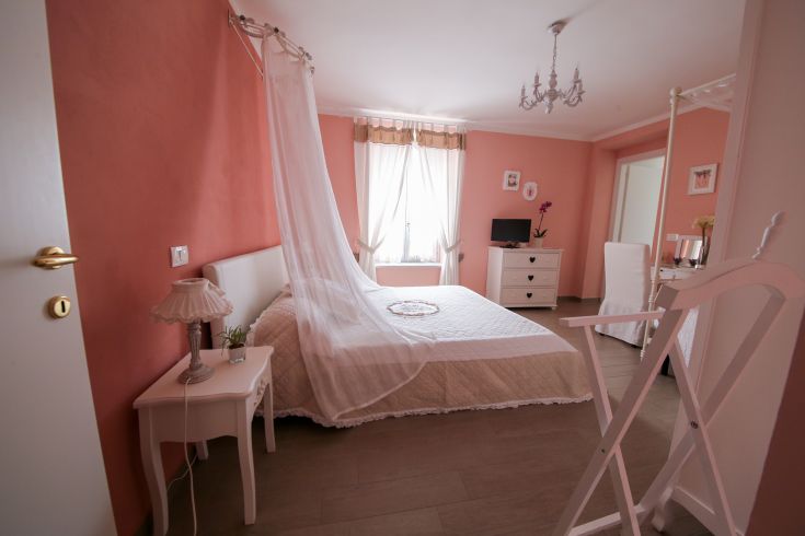 Bright shabby chic room with simple details overlooking an Umbrian landscape.