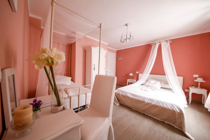 Cozy and simple room featuring shabby chic elements, with pink tones and delicate furnishings.