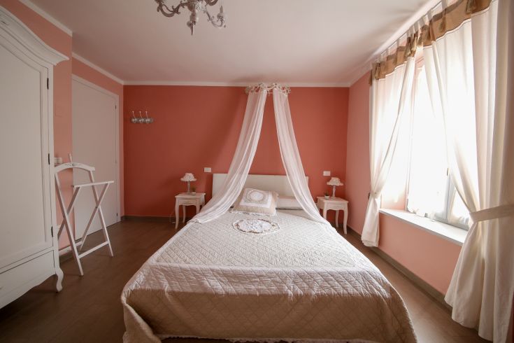 Simple shabby chic bedroom with light wood furniture and cozy details.