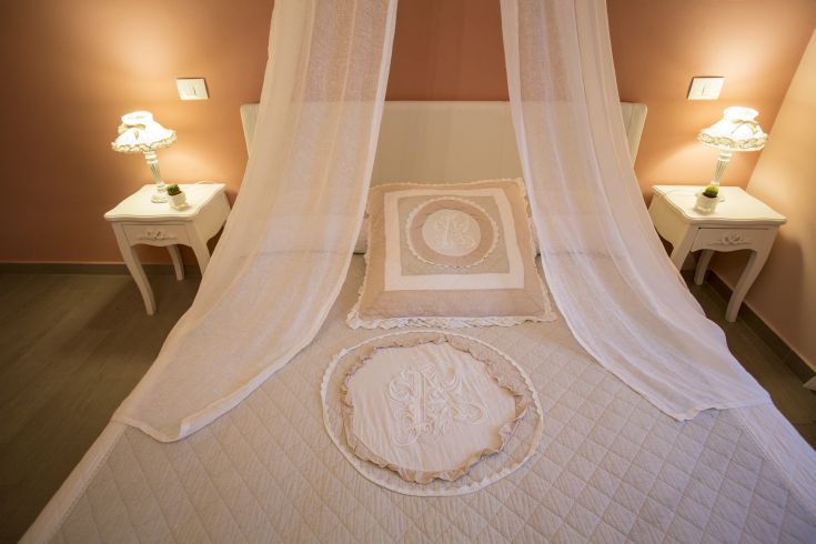 A neutral-tone bedroom with well-made beds and some country-style details.