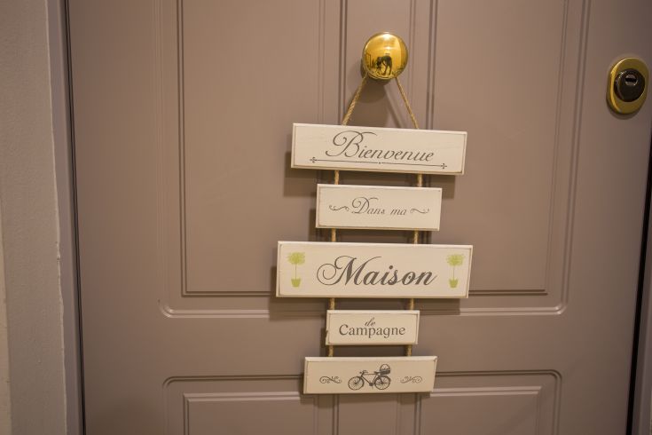 Entrance of a rural building with a welcoming sign attached to the door.