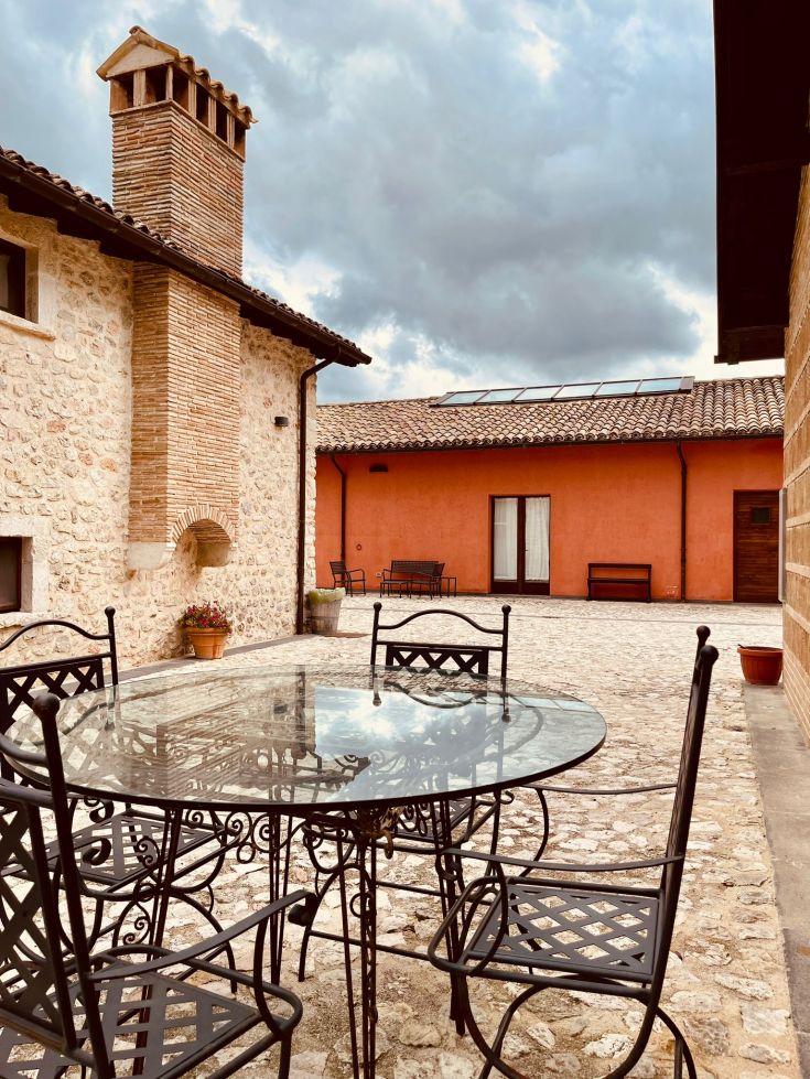 Un patio semplice con tavolo e sedie, immerso in un contesto di edifici storici.