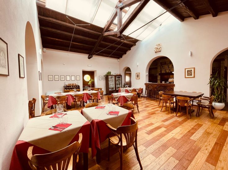 Un ristorante accogliente con tavoli ben apparecchiati. L'ambiente è luminoso e curato.