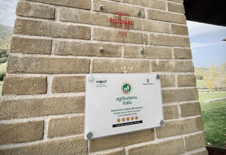 Targa segnaletica dell'agriturismo Montebello, situato in un ambiente verdeggiante e tranquillo.