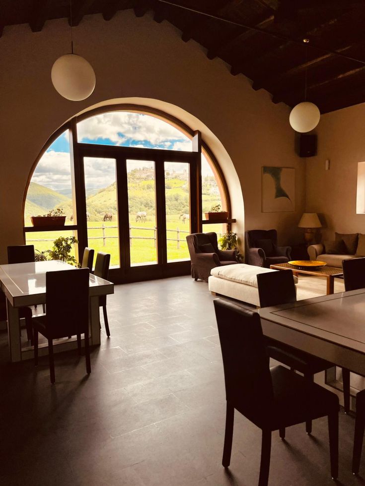 Interno di un accogliente agriturismo con panorama sulle colline circostanti.
