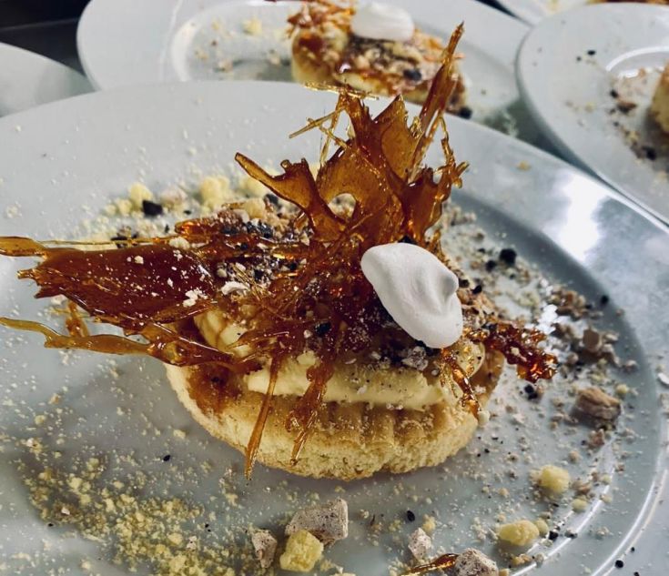 Un dessert raffinato guarnito con caramello e panna fresca.