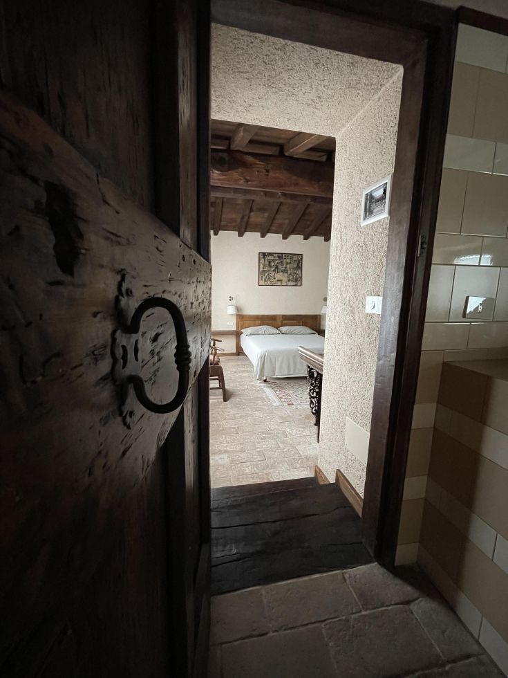 Ambiente caldo di una camera con porta in legno e elementi rustici.