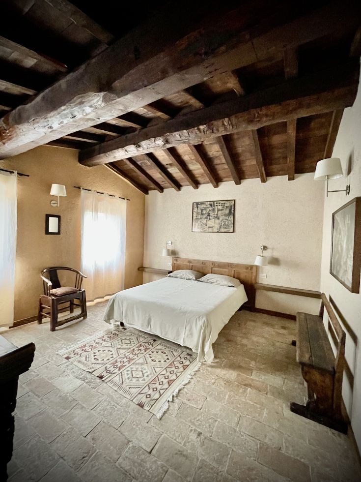 Camera semplice con soffitto in legno e dettagli rustici.