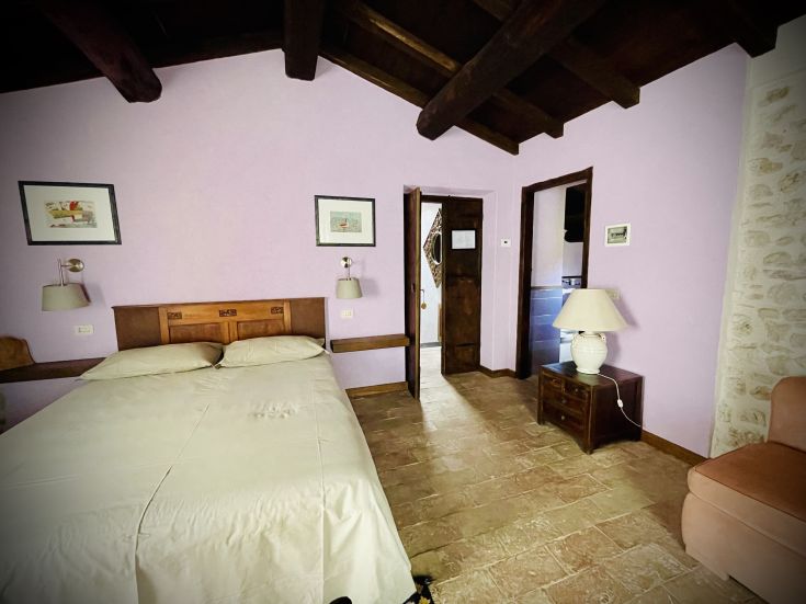 Stanza semplice con elementi in legno e tonalità chiare, ideale per un soggiorno tranquillo.