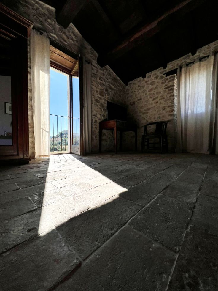 In una camera confortevole, un raggio di sole entra da una finestra aperta, illuminando l'ambiente.