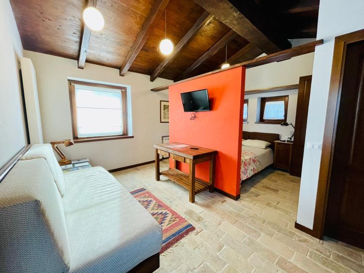 Interno di una camera da letto con arredi semplici e un'atmosfera confortevole.