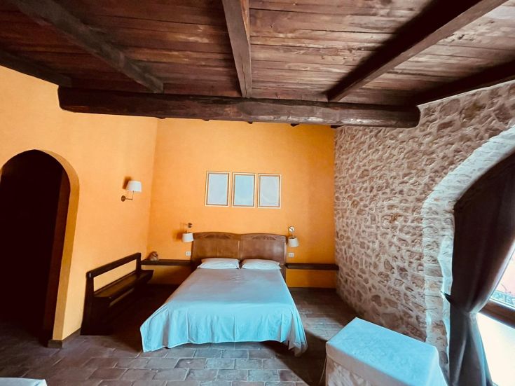 Camera con arredi semplici e tonalità calde, in un ambiente rilassante e confortevole.